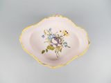 a small bowl with flowers on it sitting on a table