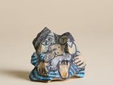 figurine représentant un homme et une femme assis sur un rocher