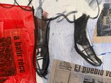 a painting of a man ' s shoes and newspaper on a table