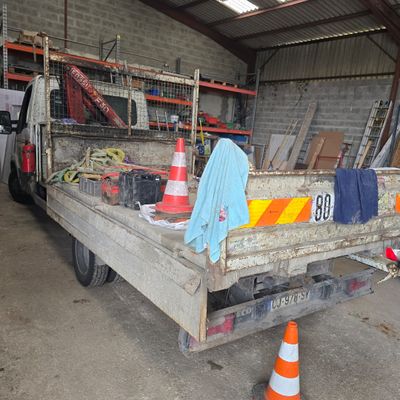 un camion garé dans un garage, avec du matériel de chantier à l'arrière