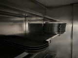 many plates stacked on a shelf in the kitchen