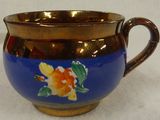 an image of a blue and gold cup with a flower on it