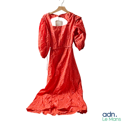 a red dress hanging on a hanger on a white wall