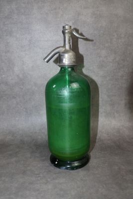 une bouteille en verre vert munie d'une pompe métallique sur le goulot