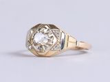 a close up of a gold ring with a diamond in the center
