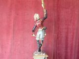 statue of a woman holding a candelabra on a pedestal