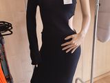 a mannequin in a room with clothes on a rack