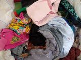 a pile of clothes that is sitting on a bed