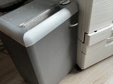 a printer sitting next to a trash can on the floor