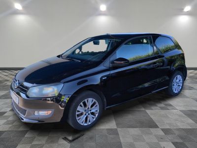 the black volkswagen polo is parked in a room with a checkered floor