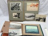 beaucoup de vieilles photos posées sur une table, à côté d'un livre ouvert