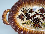 a brown and yellow bowl with a floral design on it