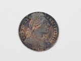 une vieille pièce de monnaie sur laquelle figure une tête de femme