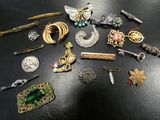 many different types of brooches and pins on the table