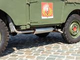 a green military vehicle parked on a cobblestone street