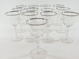 six clear wine glasses are lined up in a circle on a white surface