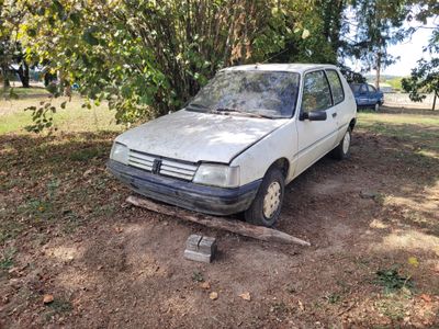 a white car that is parked in the dirt