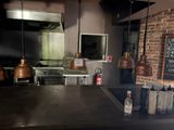 une photo de la cuisine d'un restaurant avec un tableau noir accroché au mur