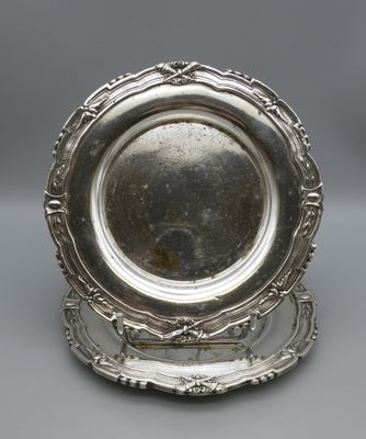 a silver plate on a stand on a gray surface