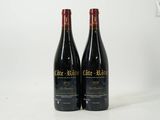 deux bouteilles de vin posées sur une table blanche