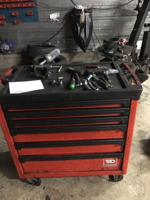 une boîte à outils rouge sur laquelle sont posés des outils, dans un garage