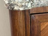 a marble sink in the corner of a wooden cabinet