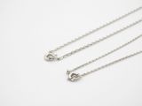 a close up of two silver chain necklaces on a white surface