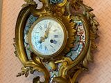a gold clock on the wall in the corner of the room