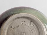 a close up of a green and brown vase with writing on it