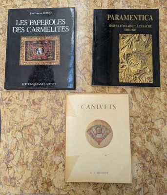 three books on a table with a clock on top of it