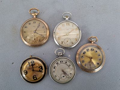 quatre montres de poche différentes posées sur une table