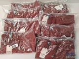six red shirts wrapped in plastic bags on a white surface