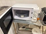 a microwave sitting on a small table in the kitchen