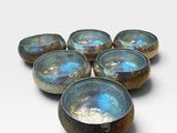 six blue and brown bowls sitting on top of a white surface