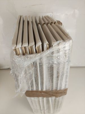 a stack of books wrapped in plastic on a table