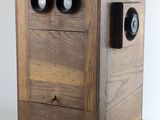 a wooden box with two eyes on top of it