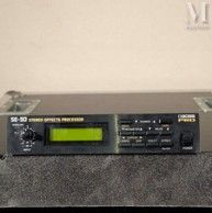 La radio est posée sur la table, près du mur.