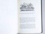someone is holding a book open to a page with a picture of a garden