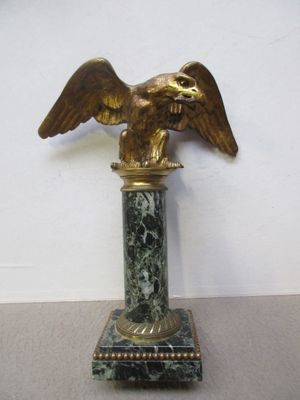 une statue d'aigle posée sur un socle en marbre