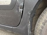 a car that has been dented and is parked on the side of the road
