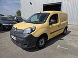 the small yellow van is parked in front of a building