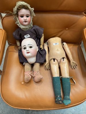 two dolls that are sitting on a chair together