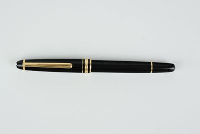 un stylo noir et or posé sur une surface blanche