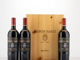 trois bouteilles de vin rouge devant une caisse en bois