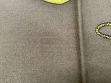 a close up of a polo shirt with a yellow and black logo on it