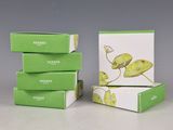 trois boîtes de thé vert posées sur une table blanche