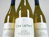 three bottles of white wine sitting on top of a table