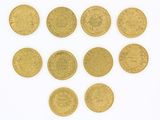 plusieurs pièces d'or sont disposées en cercle sur une surface blanche