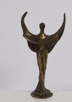 bronze statue of a woman holding a crescent on a white surface