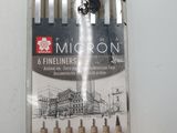 six fineliners in a package on a white surface